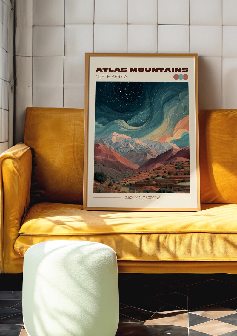 May include: A framed art print of the Atlas Mountains in North Africa. The artwork depicts a mountain range under a starry sky, with shades of blue, orange, and white. The print is displayed on a yellow sofa.