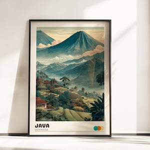 Op de afbeelding: Een ingelijste kunstafdruk met een schilderachtig uitzicht op Java, Indonesië. Het kunstwerk toont weelderige groene rijstterrassen, traditionele gebouwen en majestueuze bergen onder een bewolkte hemel. De woorden "JAVA" en "INDONESIA" staan onderaan afgedrukt.