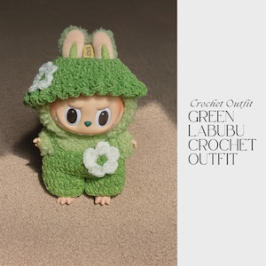 Puede incluir: Un conjunto de crochet verde para una muñeca Labubu, con un sombrero con orejas de conejo y un detalle de flor. El conjunto incluye un mono a juego con una flor blanca. El texto a la derecha dice "Crochet Outfit GREEN LABUBU CROCHET OUTFIT."