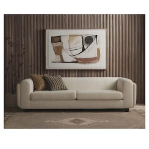 Könnte beinhalten: Ein cremefarbenes Sofa mit zwei Kissen steht auf einem gemusterten Teppich. Über dem Sofa hängt ein abstraktes Gemälde in einem Holzrahmen. Der Hintergrund zeigt eine Wand mit Holzlatten, die einen warmen Wohnraum schafft.