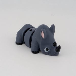 May include: A set of three ceramic mugs with a speckled, matte finish. The mugs are in shades of cream, light gray, and dark gray. Each mug has a simple, minimalist design, perfect for coffee or tea.