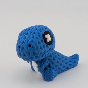 May include: A blue 3D-printed dinosaur figurine with a textured surface. The dinosaur has a white belly and a black and white eye. The figurine is a cute and whimsical decorative item.
