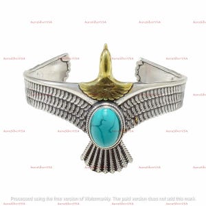 May include: Silver cuff bracelet with an eagle motif and a turquoise stone. The eagle has gold-coloured accents and detailed wing patterns. The bracelet is a statement piece with a Southwestern aesthetic.