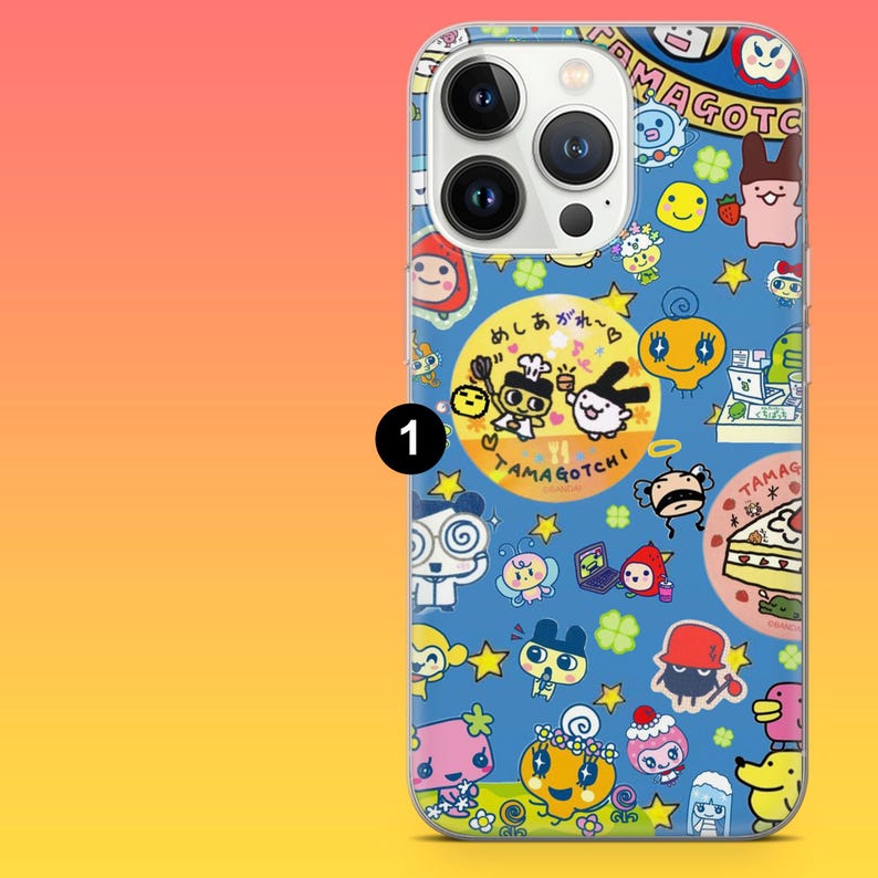 May include: A blue phone case featuring a colorful pattern of cartoon characters and the text "TAMAGOTCHI". The case has a clear border and a camera cutout.