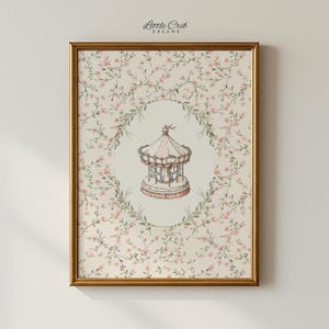 May include: A framed print featuring a carousel illustration. The carousel is in the center, surrounded by a floral wreath and a background of delicate floral patterns. The frame is gold, and the print has the text "Little Crib Dreams" at the top.