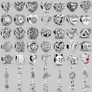 May include: A selection of silver charm beads with diverse designs, such as hearts, flowers, and animal figures. Some charms feature clear or pink gemstones, while others have detailed openwork patterns. These charms are suitable for bracelets and necklaces.