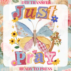 May include: A DTF transfer design featuring a patchwork butterfly with blue, yellow, and pink wings, surrounded by crocheted flowers and the words "Just Pray." The design includes a cross and the text "Ready to Press."