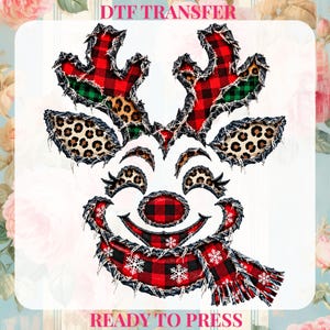 May include: A DTF transfer graphic featuring a reindeer face with a red and black buffalo plaid nose, scarf, and antlers. The design includes leopard print accents on the ears and antlers, with white snowflake patterns on the scarf.