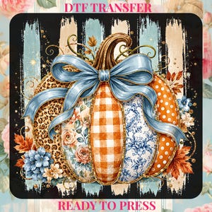 May include: A DTF transfer featuring a pumpkin with segments of leopard print, orange gingham, floral patterns, and orange polka dots. A large light blue bow sits on top. The background has black and light blue vertical brush strokes. Text reads DTF TRANSFER READY TO PRESS.
