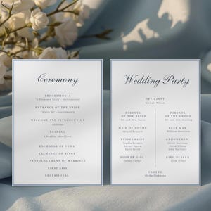 以下が含まれることがあります： 「Ceremony」と「Wedding Party」の文字が筆記体で書かれた、水色の縁取りのあるエレガントな結婚式のプログラムが2つ。プログラムには、イベントの順番と結婚式の詳細が記載されています。背景には白い花があります。