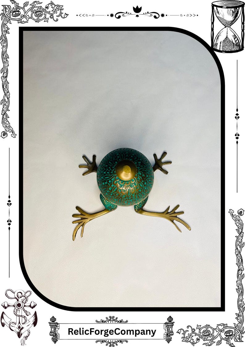 May include: A detailed, antique-style frog sculpture with a teal and gold finish. The frog has a textured body and outstretched legs, with the text "RelicForgeCompany" at the bottom. The sculpture is set against a white background.