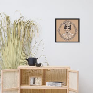 May include: Framed portrait of a woman in a vintage style, with a detailed pencil drawing. The portrait is set within an ornate oval frame, and the background is a warm, neutral tone. The frame is black, and the artwork is displayed on a wall.