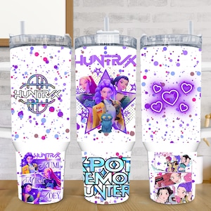 May include: White tumbler with a handle and a lid, featuring a design with the text "HUNTRAX" and images of anime characters. The tumbler has a purple and blue splatter pattern and a straw.