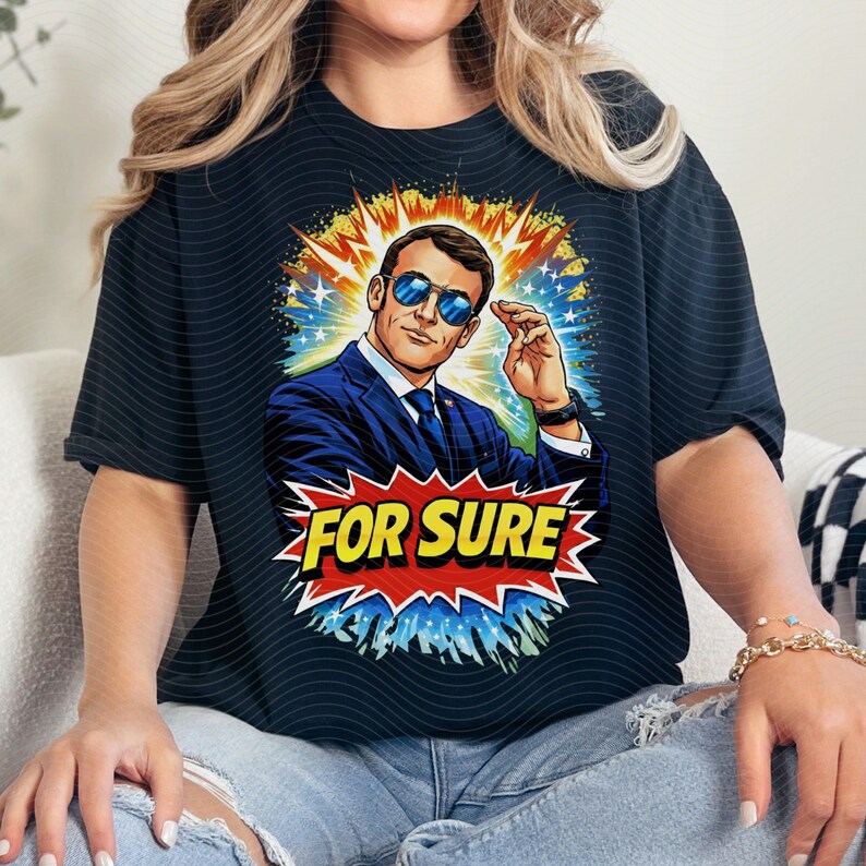 以下が含まれることがあります： 黒いTシャツ。スーツとサングラスをかけた男性の漫画風イラスト。グラフィックには、赤と黄色の爆発で「FOR SURE」というテキストが含まれています。