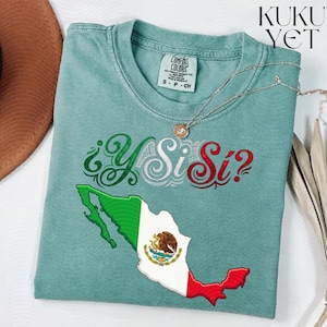 Peut inclure: Un t-shirt à manches courtes vert sauge avec un graphique de la carte du Mexique aux couleurs du drapeau national et le texte ¿Y Si Sí? dans une police décorative. Le t-shirt porte une étiquette de la marque Comfort Colors à l'encolure.
