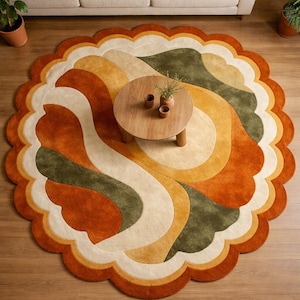 May include: A round, retro-style rug with a scalloped edge. The rug features a wavy pattern in shades of orange, green, cream, and yellow. A small, round wooden coffee table sits in the center of the rug.