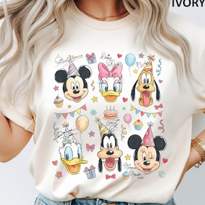 Puede incluir: Camiseta de color marfil con ilustraciones coloridas de Mickey Mouse, Daisy Duck, Pluto, Donald Duck, Goofy y Minnie Mouse, todos con sombreros de fiesta. El dise&ntilde;o incluye elementos tem&aacute;ticos de cumplea&ntilde;os como globos, cupcakes y confeti.