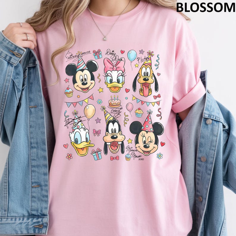 Puede incluir: Camiseta rosa claro con un gr&aacute;fico colorido de los personajes de Disney Mickey Mouse, Minnie Mouse, Donald, Daisy, Goofy y Pluto, con decoraciones de fiesta. La palabra "BLOSSOM" est&aacute; impresa en la parte superior derecha.