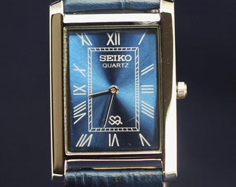 Seiko slank quartz uurwerk in blauwe wijzerplaat herenpolshorloge in werkende staat.