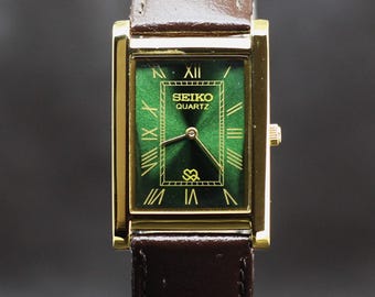 Seiko slank quartz uurwerk met groene wijzerplaat herenpolshorloge in werkende staat.