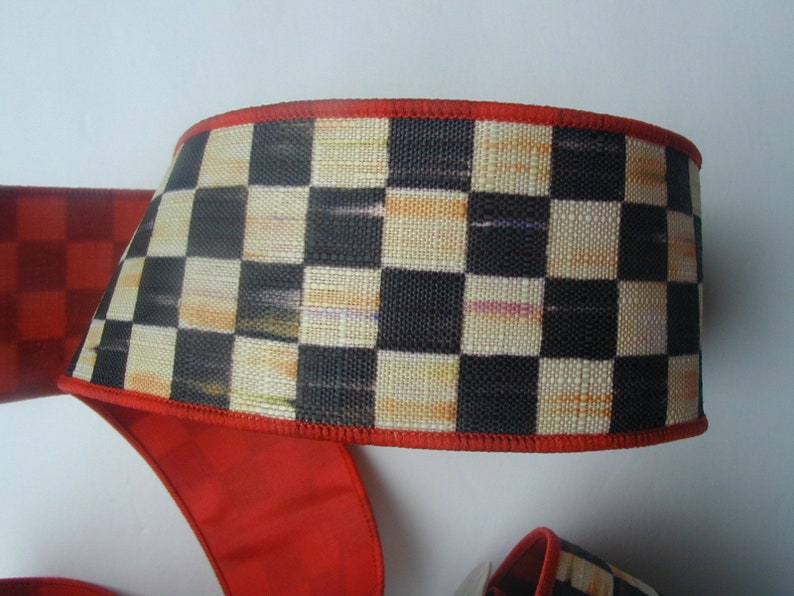 May include: Black and white checkered ribbon with a red edge. The ribbon is made of a woven fabric with a subtle texture.