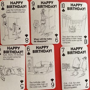Puede incluir: Seis cartas de juego con la frase "HAPPY BIRTHDAY!" en la parte superior. Cada carta presenta una ilustración de dibujos animados en blanco y negro y texto humorístico. Las cartas están dispuestas sobre una superficie roja.