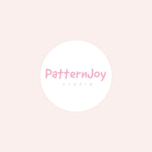 Pode incluir: Um logótipo circular branco centrado num fundo rosa pálido. O logótipo apresenta o texto PatternJoy numa fonte cursiva rosa, com a palavra STUDIO impressa em letras maiúsculas rosa mais pequenas e espaçadas logo abaixo.