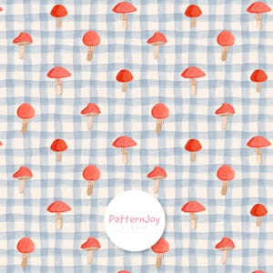 Pode incluir: Um padrão repetitivo de cogumelos vermelhos em aguarela sobre um fundo creme claro com uma grelha azul suave. Um logótipo circular branco com o texto PatternJoy Studio está centrado sobre o padrão, obscurecendo parcialmente o design.