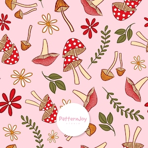 Pode incluir: Um padrão repetitivo de cogumelos vermelhos com bolinhas brancas, caules laranja-castanho, flores e folhas sobre um fundo rosa claro. O design inclui o texto "PatternJoy Studio" num círculo branco.