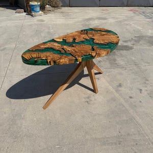 “Top view of emerald epoxy resin river and natural olive wood grain – artisanal handmade table”
