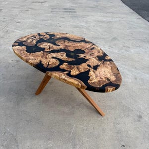 Olive wood surface with clear epoxy river — handcrafted centerpiece table