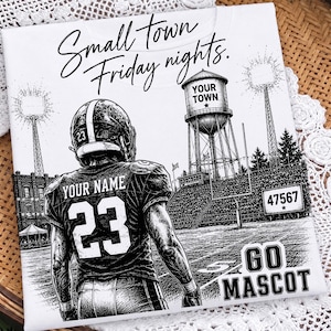 Op de afbeelding: Een wit t-shirt met een zwart-witte afbeelding van een footballspeler in een shirt met nummer 23 en de tekst YOUR NAME. Het ontwerp bevat een watertoren met de tekst YOUR TOWN, een stadion en de tekst Small town Friday nights.
