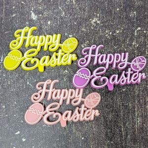 May include: Three colorful Easter decorations with the words "Happy Easter". The decorations are in yellow, purple, and pink, each with a matching egg design. The text and egg outlines are white.