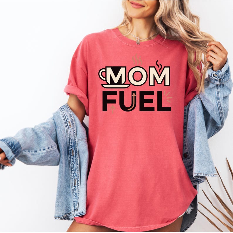 Mom Fuel retro coffee typography graphic t-shirt printed on Comfort Colors garment-dyed vintage washed heavyweight tee featuring coffee cup M letterform with steam lines and energy arrows in terracotta black and cream