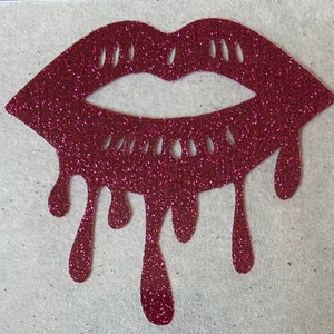 May include: A red glitter lips design with dripping glitter. The lips are outlined in a darker red and have a cutout design.