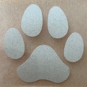 May include: A white glitter paw print on a brown background.