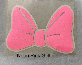 May include: A neon pink glitter bow with a white outline.  The bow is on a clear sheet with the text "Neon Pink Glitter" below it.