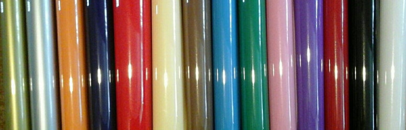 May include: A collection of 18 different colored round rods. The rods are arranged in a row from left to right. The colors are: gold, silver, orange, navy blue, red, cream, brown, light blue, dark green, pink, purple, maroon, black, white, light green, dark blue, yellow, and light purple.