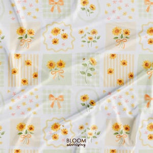 May include: A white fabric with a repeating pattern of watercolor sunflowers, bows, and bees. The design is arranged in a grid of squares with stripes, gingham, and floral backgrounds. The text "BLOOM artistry" is visible.