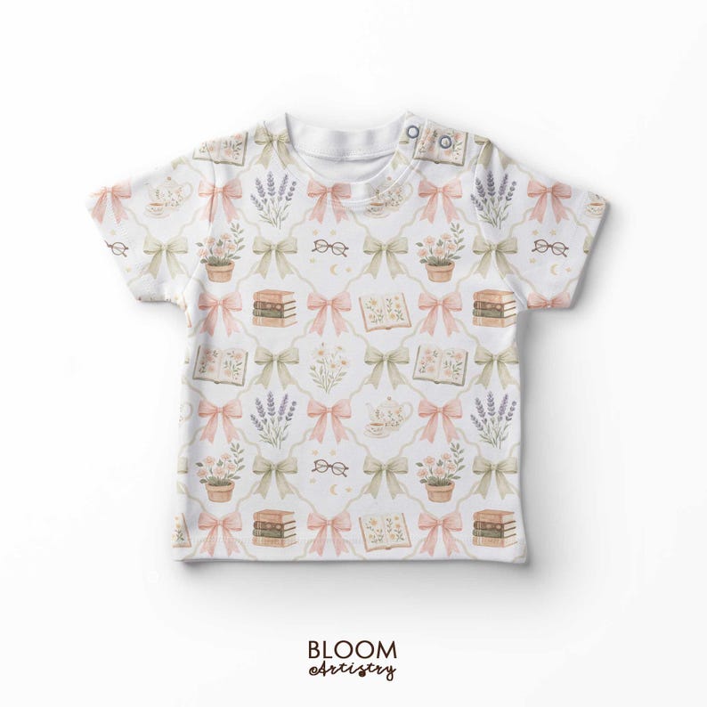 May include: White t-shirt with a repeating pattern of pink and green bows, books, eyeglasses, lavender, and potted plants. The shirt has a button closure at the neckline and the text "BLOOM artistry" at the bottom.