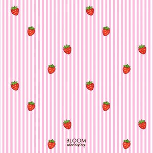 May include: A repeating pattern of red strawberries with green tops scattered across a pink and white striped background. The text "BLOOM artistry" is in the lower right corner.