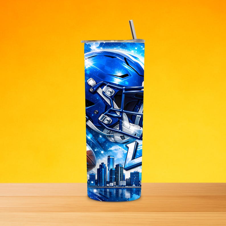 May include: A blue and white tumbler featuring a football helmet, a football, and a city skyline. The design includes the letter "L" and a silver straw. The tumbler is cylindrical and has a silver lid.