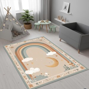 Puede incluir: Alfombra rectangular con dise&ntilde;o de arco&iacute;ris, luna y nubes, ideal para una habitaci&oacute;n infantil. La alfombra presenta un fondo beige con un arco&iacute;ris en tonos marrones y azules. Nubes blancas y estrellas doradas dispersas.