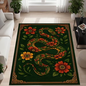 Op de afbeelding: Een rechthoekig groen vloerkleed met een gestileerd slangenontwerp. De slang is versierd met oranje en gele bloemen en bladeren. Het vloerkleed heeft een gouden rand met bloemenhoekaccenten. Het vloerkleed ligt op een lichte houten vloer.