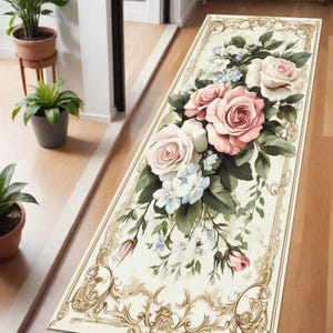 Könnte beinhalten: Rechteckiger Blumeng Teppich mit cremefarbenem Hintergrund und goldfarbenem Filigranrand. Er zeigt einen Strauß aus rosa und weißen Rosen, blauen Blumen und grünen Blättern, wodurch ein klassisches, elegantes Design entsteht.