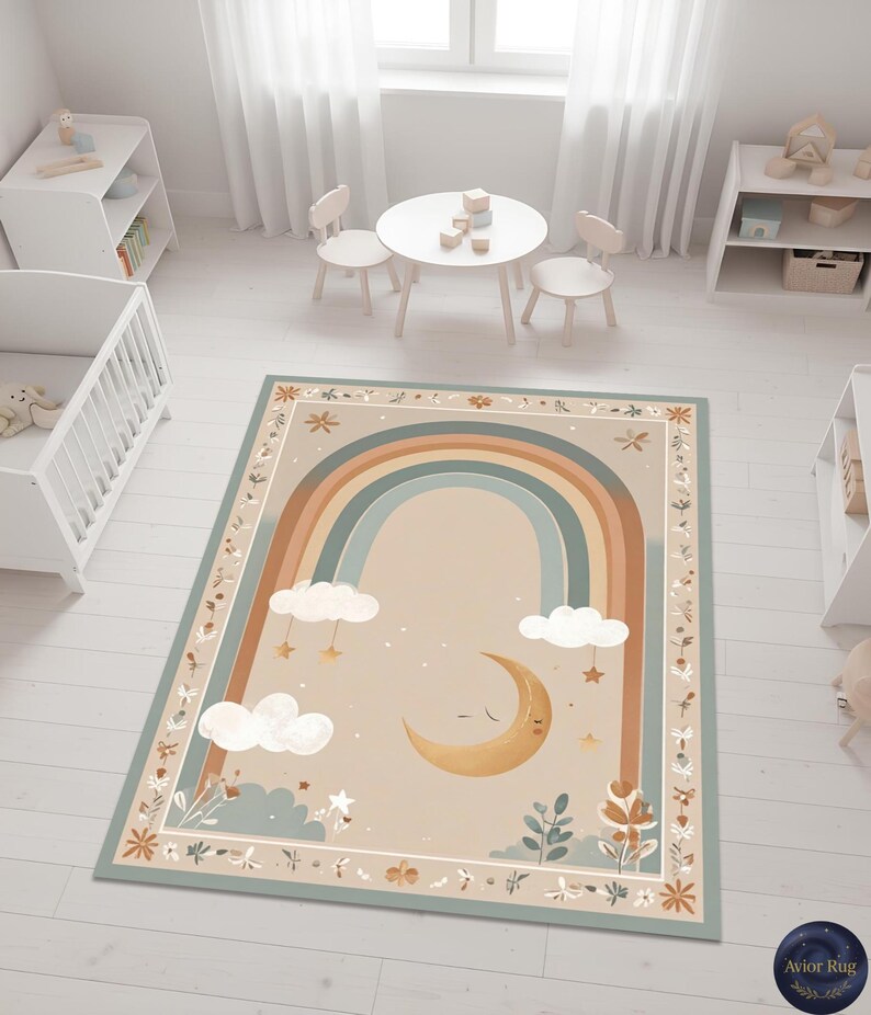 Puede incluir: Una alfombra rectangular con un dise&ntilde;o caprichoso que presenta un arco&iacute;ris, nubes, estrellas y una luna creciente. La alfombra tiene un fondo beige con un borde de patrones florales y de hojas. El arco&iacute;ris tiene tonos azules, marrones y beige.