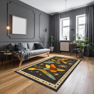 May include: A rectangular rug with a mid-century modern design. The rug has a dark background with colourful abstract shapes in orange, teal, and yellow, and starburst patterns. The border has a geometric pattern.