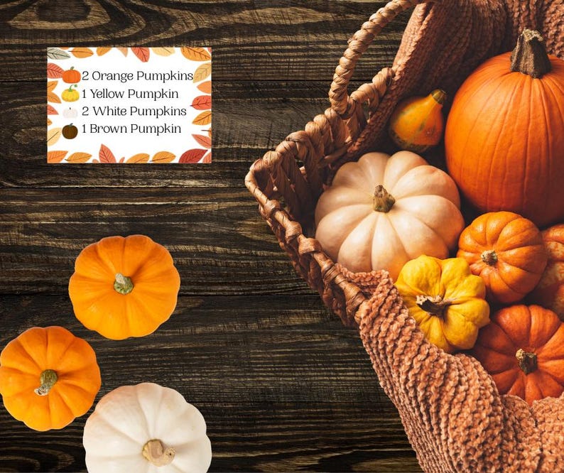 May include: A woven basket containing several pumpkins in orange, yellow, and white, with additional pumpkins placed outside the basket. A rectangular sign displays the text: 2 Orange Pumpkins, 1 Yellow Pumpkin, 2 White Pumpkins, 1 Brown Pumpkin.