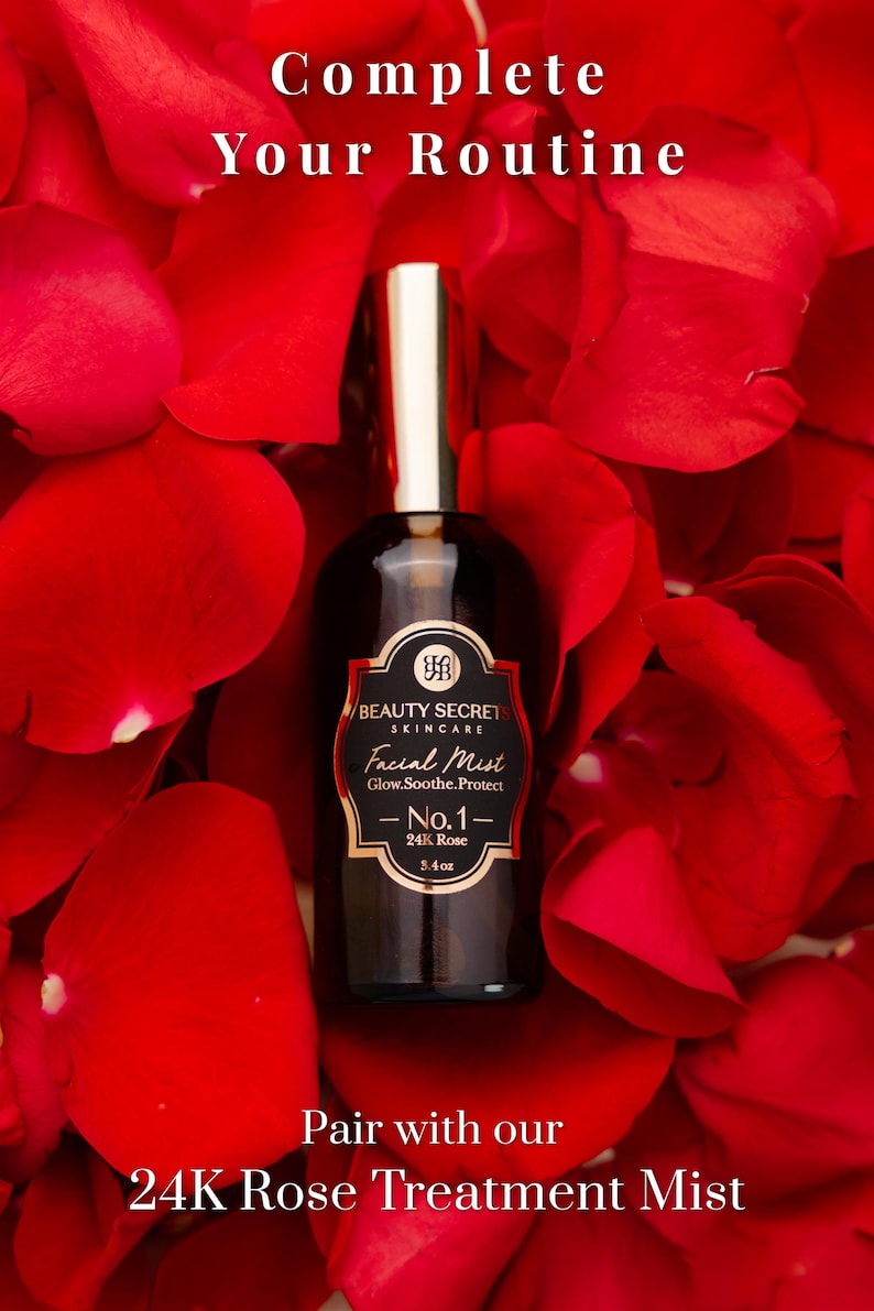 Puede incluir: Un frasco de vidrio oscuro de bruma facial Beauty Secrets Skincare No.1 24K Rose con tapa dorada, etiquetado 3.4oz, rodeado de p&eacute;talos de rosa rojos. El texto dice: Complete Your Routine y Pair with our 24K Rose Treatment Mist.
