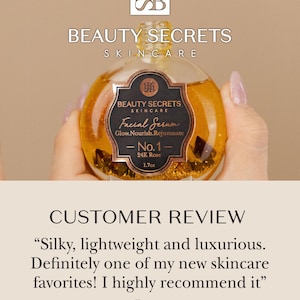 Puede incluir: Un frasco de vidrio redondo de suero facial Beauty Secrets Skincare No. 1 24K Rose con l&iacute;quido dorado y escamas. La etiqueta negra dice Beauty Secrets Skincare Facial Serum Glow.Nourish.Rejuvenate No. 1 24K Rose 50ml. Un gotero est&aacute; arriba.
